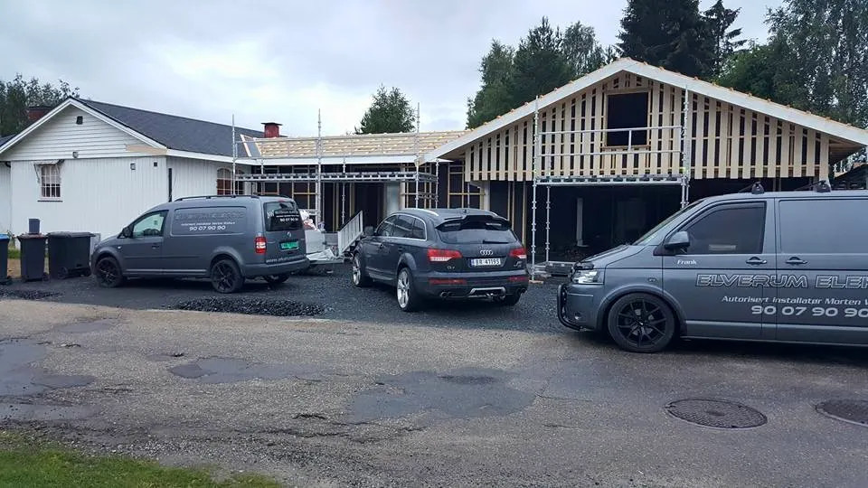 Tre firmabiler parkert foran et bygg som er under arbeid