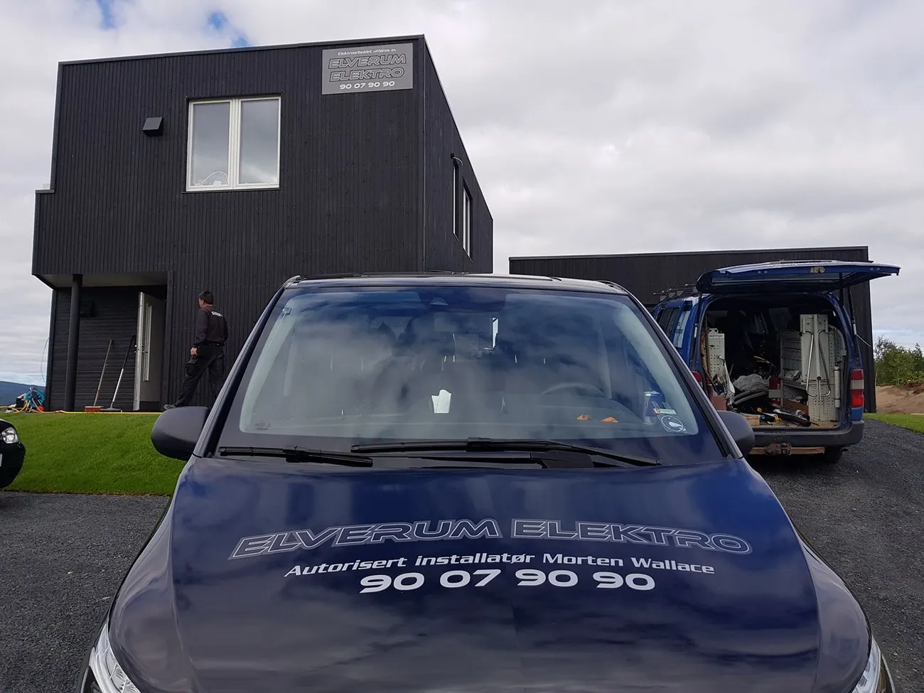 Firmabil med Elverum Elektros logo foran et mørkt panelt hus