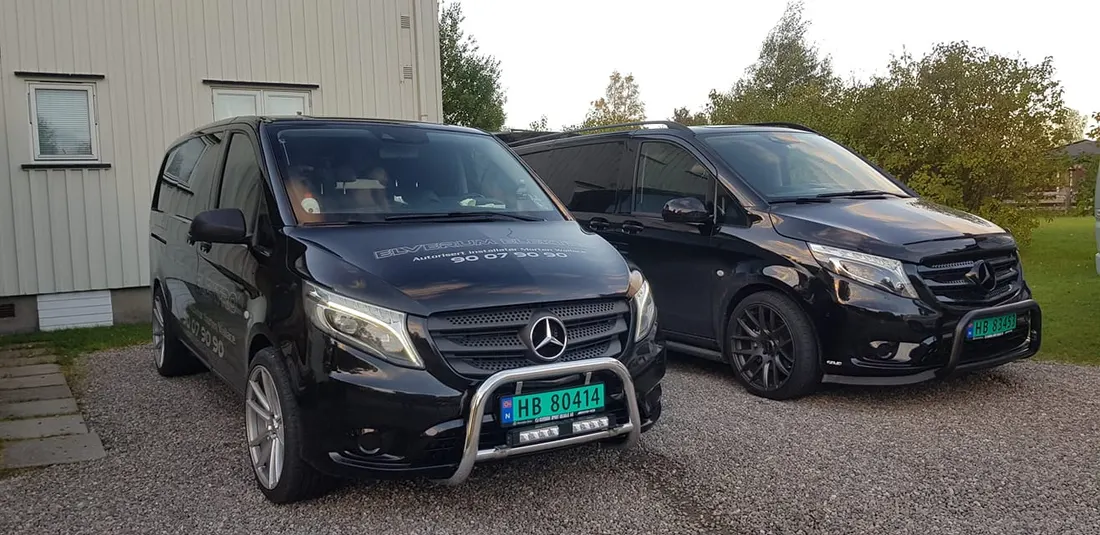 To firmabiler med Elverum Elektros logo parkert utenfor et bygg