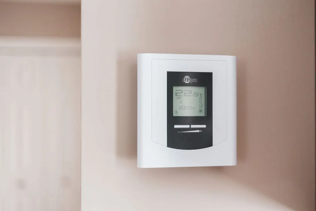 Et veggmontert styringspanel med display for varme og ventilasjon